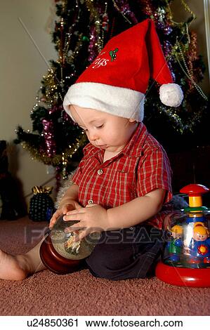Little boy with Christmas hat in front of tree View Large Photo Image Stock Image - Little boy with Christmas hat in front of tree. Fotosearch