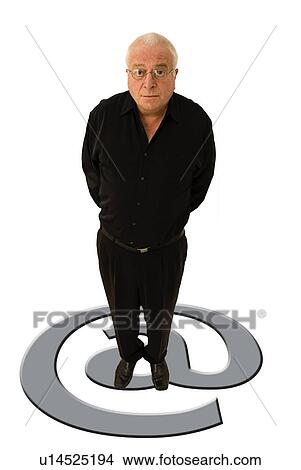 Picture - Man standing on an @ sign. Fotosearch