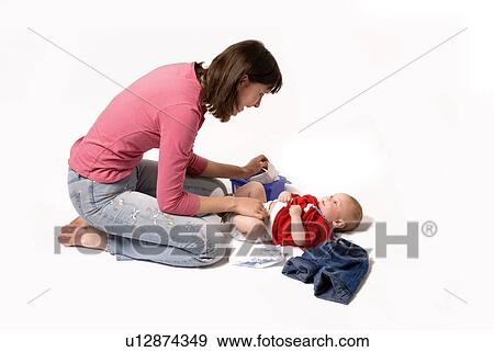 Stock Photo - Mother changing babies diaper. Fotosearch
