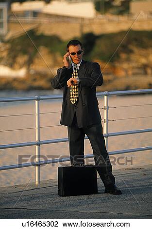 Outdoor businessman looking at his watch View Large Photo Image Stock Image - Outdoor businessman looking at his watch. Fotosearch