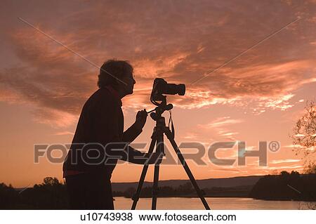 Stock Photo - Photographer taking an outdoor photo. Fotosearch