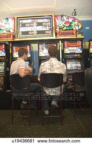 Stock Image - Playing the slots. Fotosearch