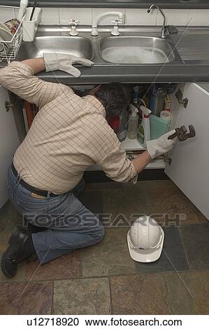 Plumber fixing a kitchen sink View Large Photo Image Stock Image - Plumber fixing a kitchen sink. Fotosearch