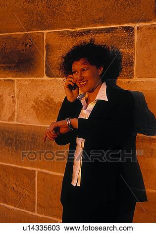 Stock Image - Professional woman on cell phone checking time. Fotosearch