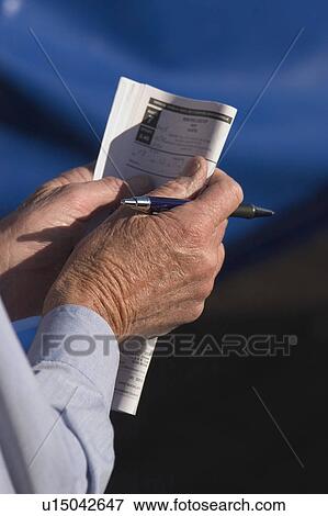 Stock Photo - Reading the guide. Fotosearch