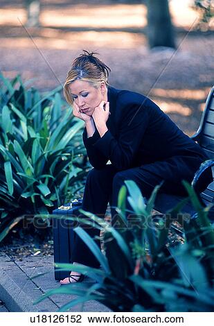Stock Image - Sad businesswoman on a bench. Fotosearch