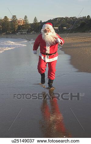Stock Photo - Santa running on the beach. Fotosearch