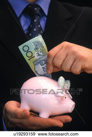 Saving in a piggy bank View Large Photo Image Stock Photo - Saving in a piggy bank. Fotosearch