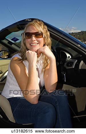 Stock Photography - Smiling woman sitting in her car. Fotosearch