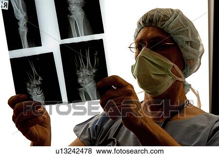 Stock Photo - Surgeon looking at x-rays. Fotosearch