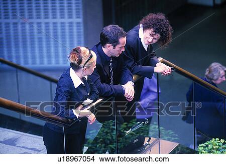 Picture - Three business people standing on stairs. Fotosearch