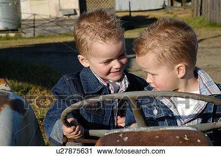 Stock Image - Two brothers on a farm tractor. Fotosearch