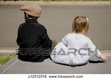 View from behind of boy and girl sitting at each of road View Large Photo Image Stock Photograph - View from behind of boy and girl sitting at each of road. Fotosearch