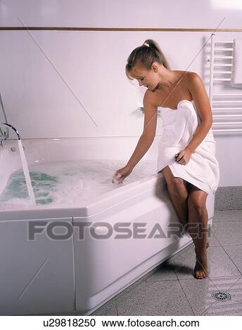Stock Image - Woman getting ready for a bath. Fotosearch