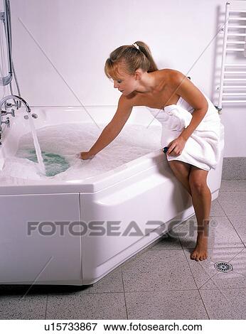 Stock Photo - Woman getting ready to take a bath. Fotosearch
