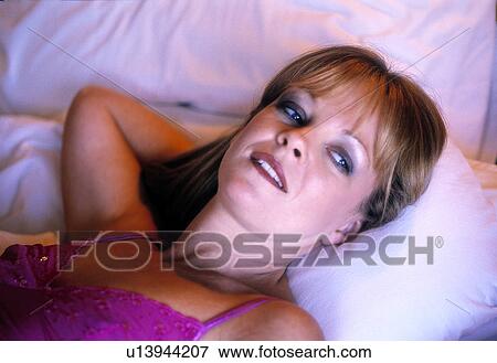 Woman in bed in the early morning View Large Photo Image Stock Photo - Woman in bed in the early morning. Fotosearch