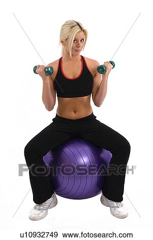 Woman lifting weights on a gym ball View Large Photo Image Stock Photo - Woman lifting weights on a gym ball. Fotosearch