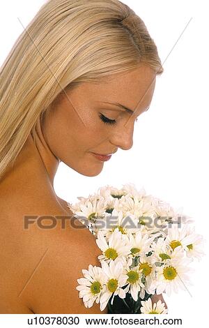 Stock Image - Woman looking down at daises. Fotosearch