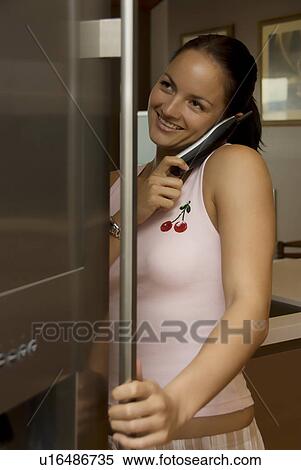 Stock Photography - Woman on telephone in her kitchen. Fotosearch