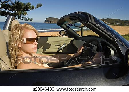 Stock Photograph - Woman parked at the beach. Fotosearch