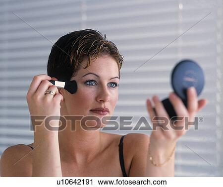 Stock Image - Woman putting on makeup. Fotosearch