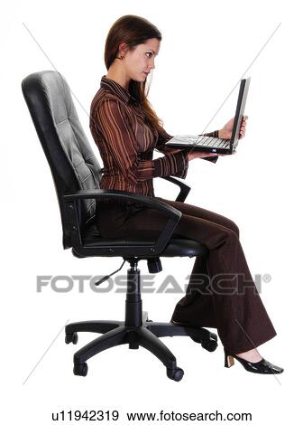 Woman sitting in a chair with a laptop View Large Photo Image Stock Photo - Woman sitting in a chair with a laptop. Fotosearch