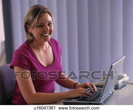 Woman working on a laptop View Large Photo Image Stock Image - Woman working on a laptop. Fotosearch