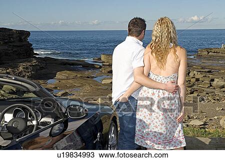 Stock Image - Young couple parked at the beach. Fotosearch