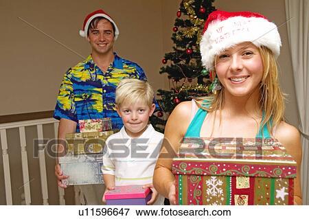 Stock Photo - Young family Christmas day. Fotosearch