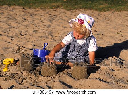 Young girl playing in sand View Large Photo Image Stock Photo - Young girl playing in sand. Fotosearch