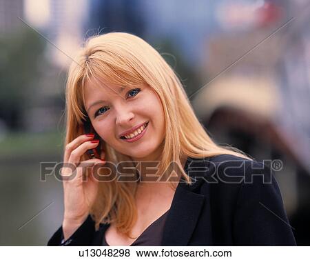 Stock Photo - Young woman talking on cell phone. Fotosearch