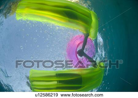 A couple on two green rafts holding hands shot from underwater View Large Photo Image Stock Photo - A couple on two green rafts holding hands shot from underwater. Fotosearch