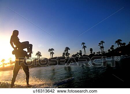 A couple tandem surfing in silhouette Ventura California USA View Large Photo Image Stock Image - A couple tandem surfing in silhouette Ventura California USA. Fotosearch