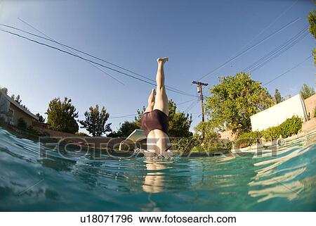 A female diving into a pool View Large Photo Image Stock Photograph - A female diving into a pool. Fotosearch
