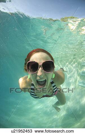 Stock Image - A female swimming under water. Fotosearch