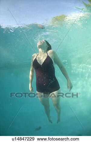 Stock Photo - A female swimming under water. Fotosearch