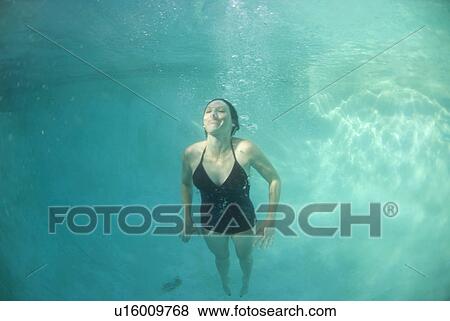 Stock Photo - A female swimming under water. Fotosearch