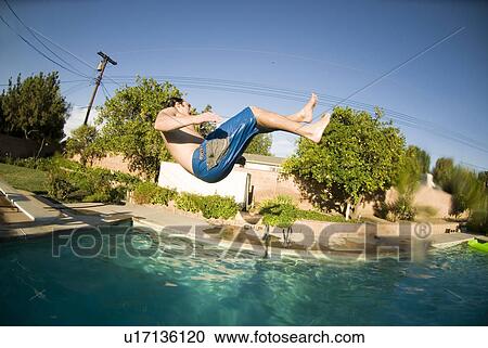 Stock Image - A male jumping into a pool. Fotosearch
