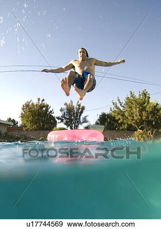 A male jumping into a pool View Large Photo Image Stock Photo - A male jumping into a pool. Fotosearch