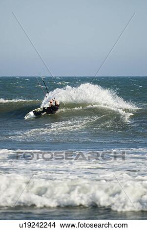 Picture - A male kite surfing. Fotosearch