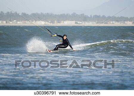 Stock Image - A male kite surfing. Fotosearch