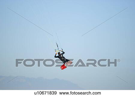 Stock Photo - A male kite surfing. Fotosearch
