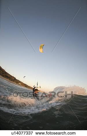 Stock Photo - A male kite surfing. Fotosearch