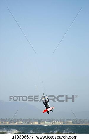 Stock Photo - A male kite surfing. Fotosearch