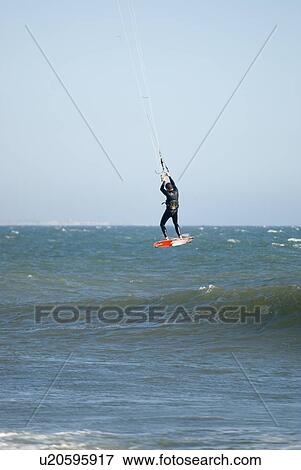 Stock Photo - A male kite surfing. Fotosearch