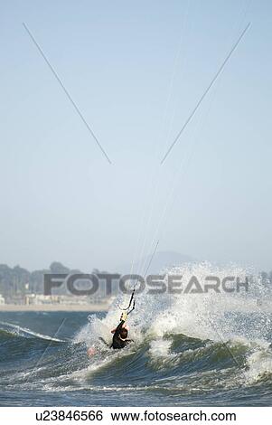 Stock Photograph - A male kite surfing. Fotosearch