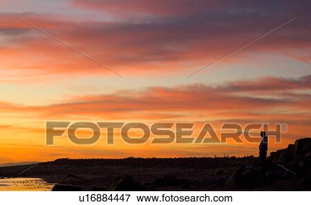 A male silhouetted at the beach during sunset View Large Photo Image Stock Photo - A male silhouetted at the beach during sunset. Fotosearch