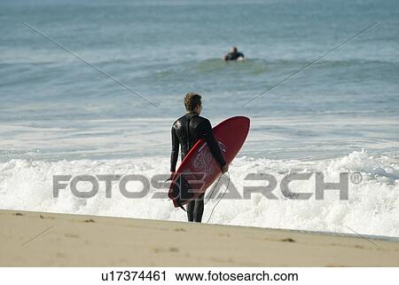 A male surfer looking out to the surf View Large Photo Image Stock Image - A male surfer looking out to the surf. Fotosearch