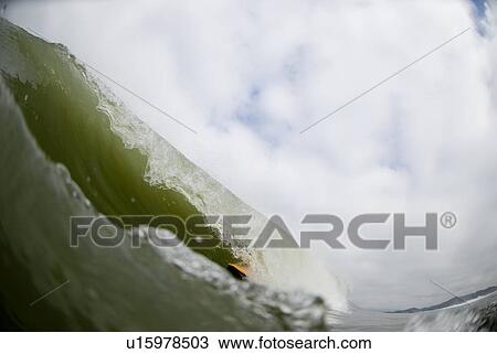 Stock Image - A male surfing. Fotosearch
