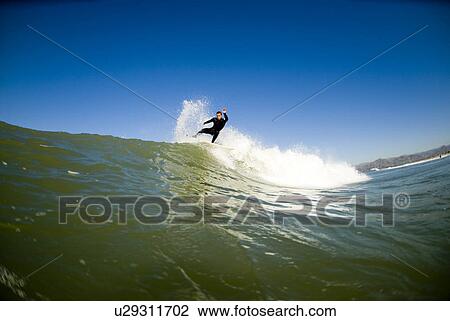 Stock Image - A male surfing. Fotosearch
